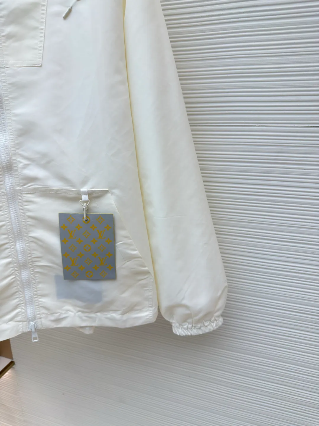 LOUIS VUITTON double-sided windproof pin jacket ●Authentic product: purchased and developed for 22700 ●Item number: 1680474-C55 ●Fabric: polyester fiber fabric ●Technology: jacquard ●Version: fitted version ●Weight: about 555 grams ●Size: 44-46-48-50 ●Description: The solid color fabric is made of nylon encrypted matt twill fabric, and the jacquard fabric on the other side is made of 50D nylon yarn-dyed jacquard fabric. The solid color front panel is laser-burned, hand-made of white copper, with a triangle pin with logo and glossy finish. The front panel pocket uses a hardware keychain to hang a folding clothing tag, and the jacquard letters on the front chest placket are made of single-piece flowing pure It is cut by hand to restore the flower, and all the pieces are numbered. The pockets are also cut with the restored flower number. The fabric is relatively light and silky, and it takes time to cut accurately. The front and center are equipped with a double-circulation puller 5# orbital zipper. The hem and the hood are worn with spiral elastic ropes with ring anti-slip buckles, square pig nose buckles with logo, and all holes are punched with hardware and logo on the cloth-colored cornrows.